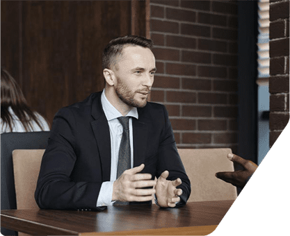 the man in black coat sitting in the office and give the best solution for grow your business